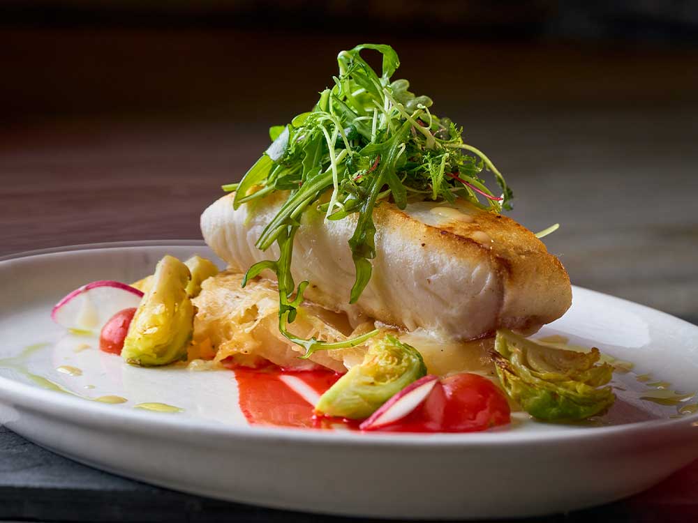 Fine dining fish and vegetables on white plate