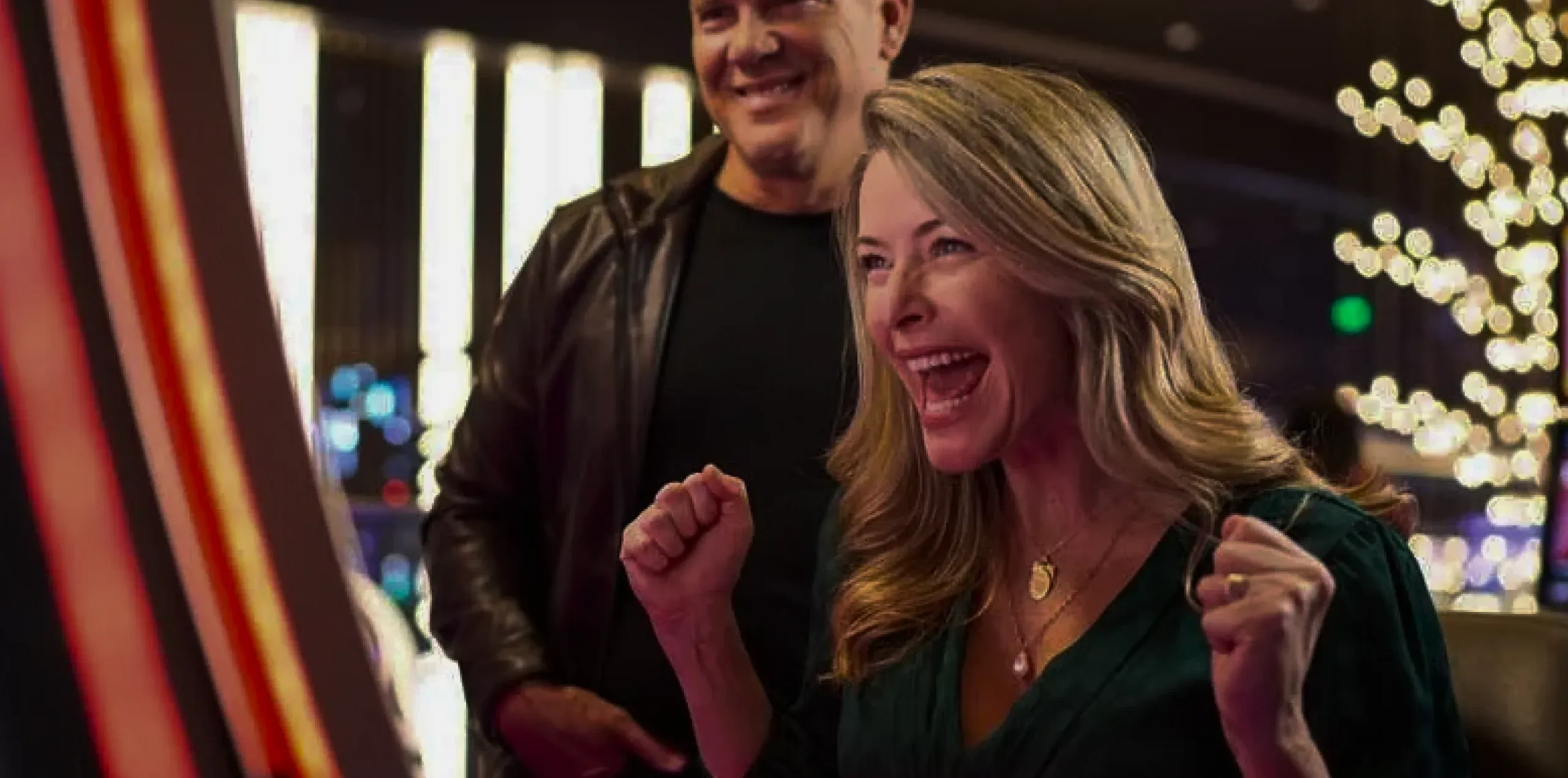 A couple celebrating a win on the Emerald Queen Casino slot floor